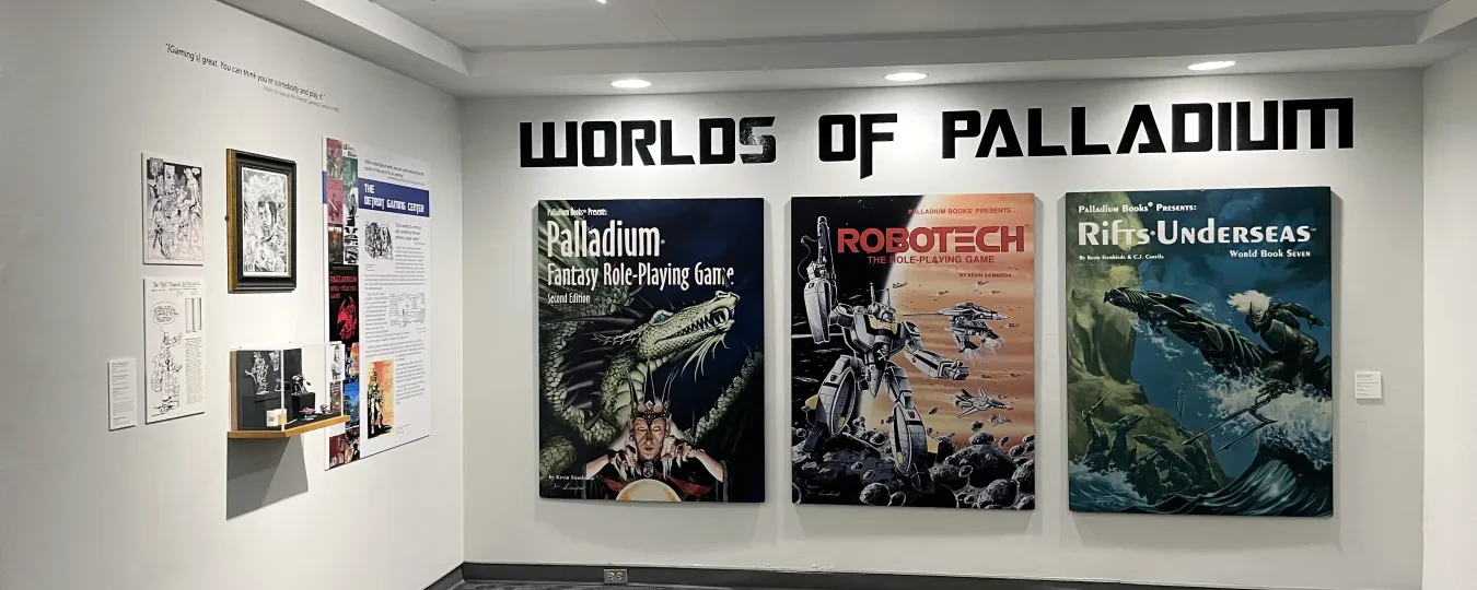 Exhibition wall with "Worlds of Palladium" posters, showcasing sci-fi themes and artwork.