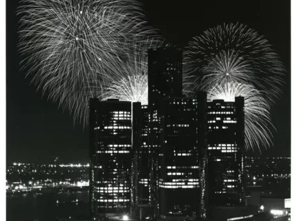 Fireworks illuminating a city skyline at night.