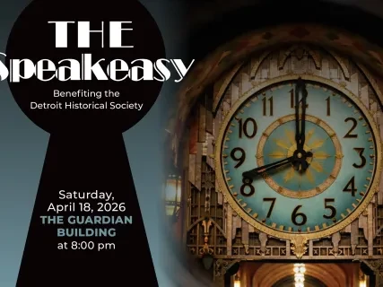 Keyhole view showing an ornate clock face with blue and gold accents next to event text on a dark background.