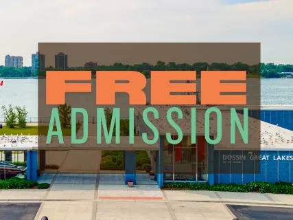 Building entrance with "Free Admission" text overlay, river and city skyline in background.