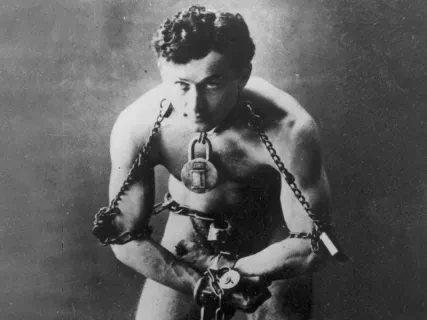 Man in chains, focused expression, black and white photograph.