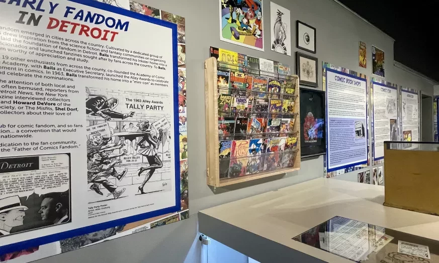 Exhibit wall with comic book memorabilia and historical panels in a museum setting.