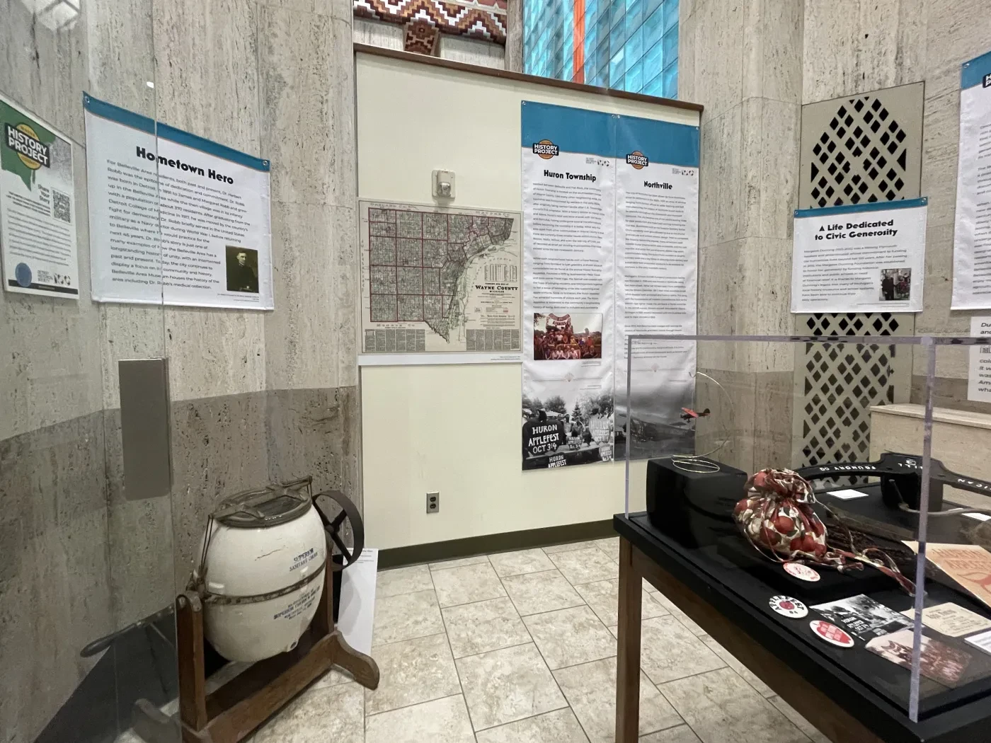 Exhibit room with historical posters, artifacts, and a display case.