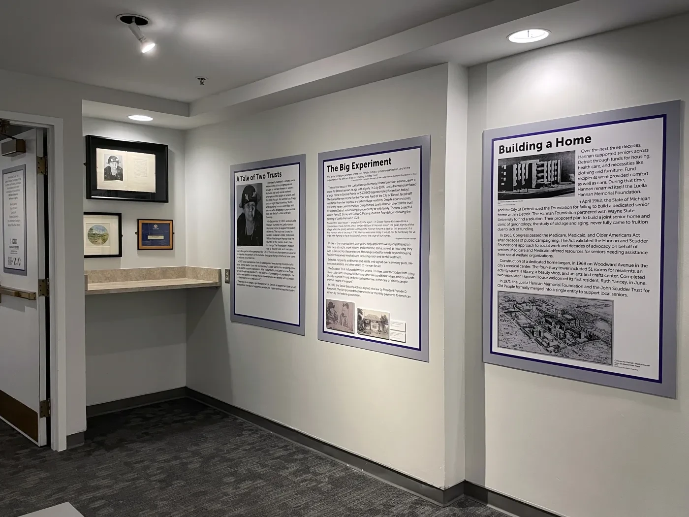 Hallway with framed historical documents and photographs displayed on the walls.