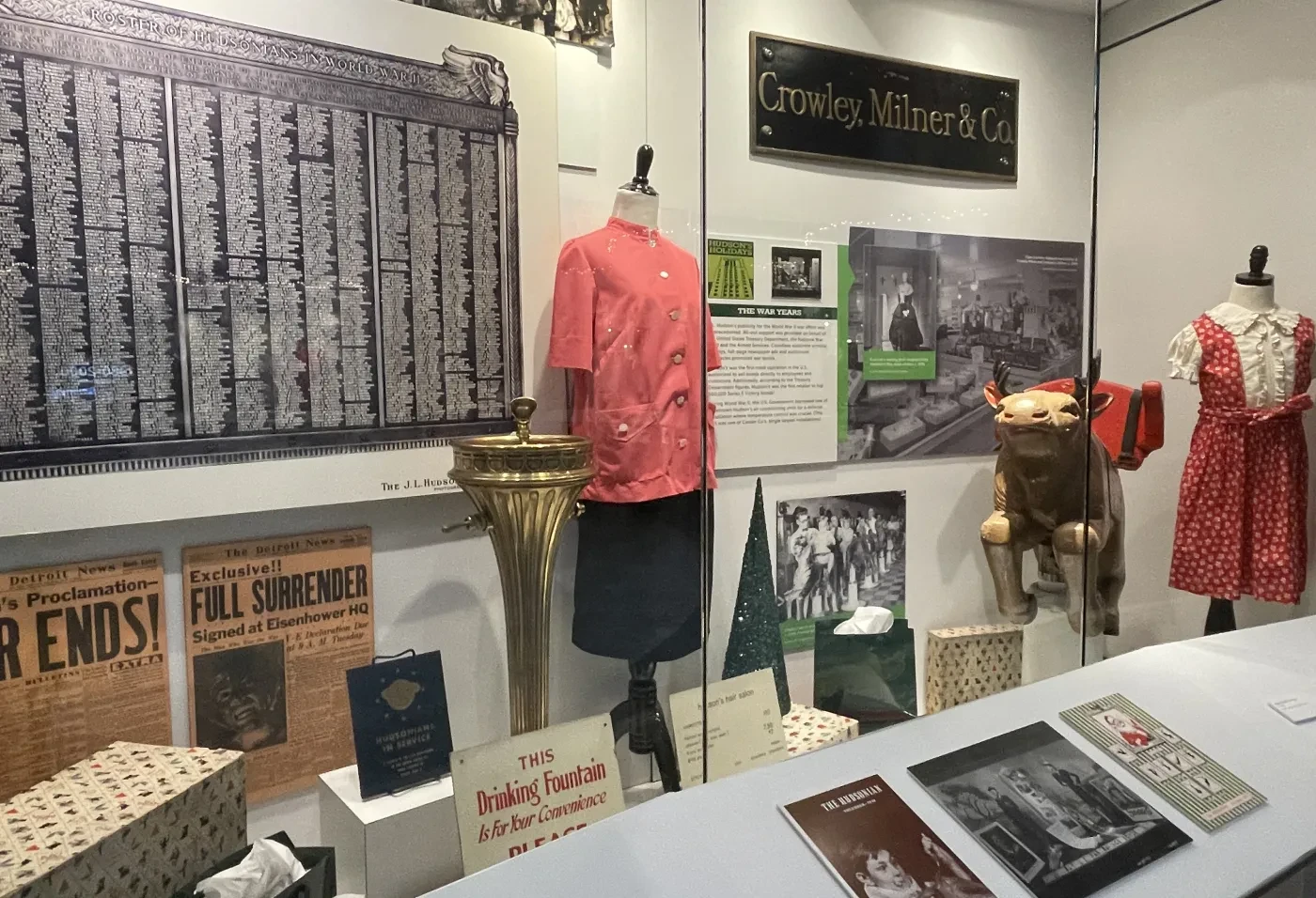 A museum display with vintage clothing, posters, and documents related to the garment industry.