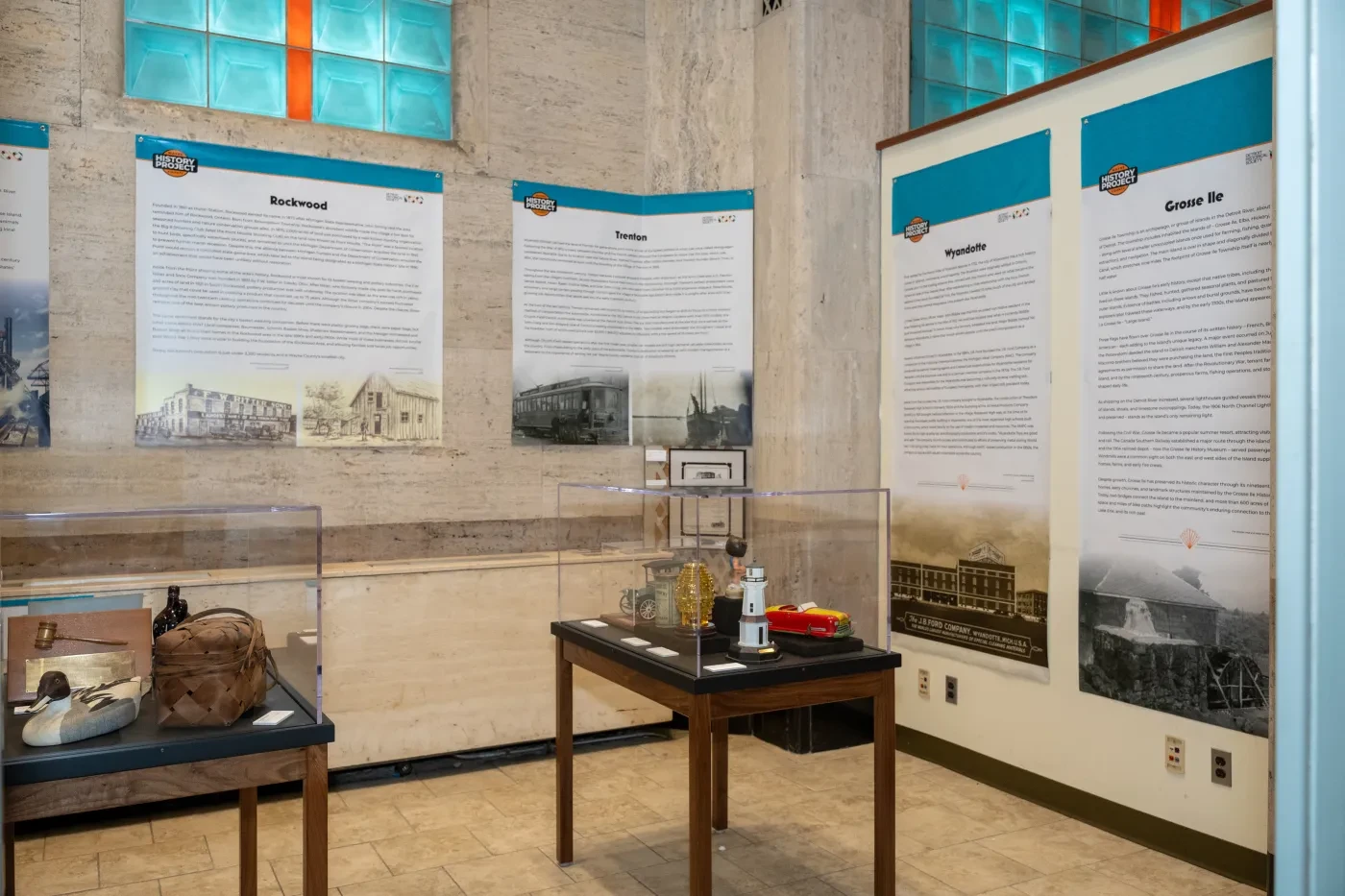 Exhibit room with historical displays, text panels, and artifacts on tables.